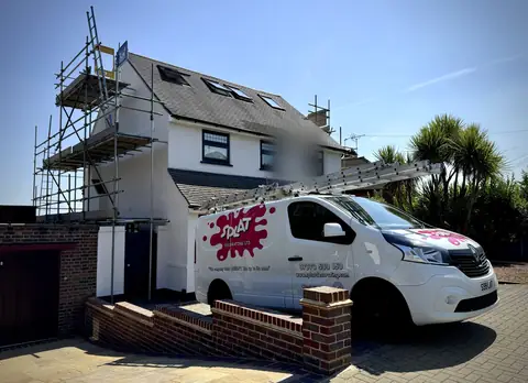 Splat Decorating van with ladders on the drive beside a white painted house with scaffold on the gable end