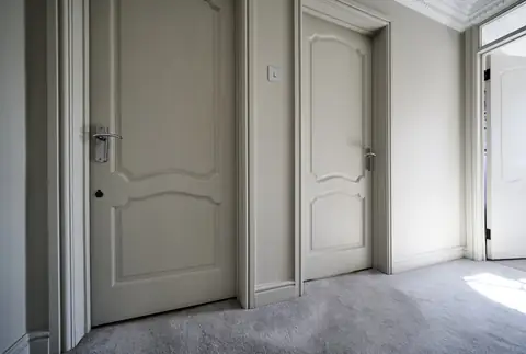 Two panelled landing doors and their frames painted the same shade as the walls