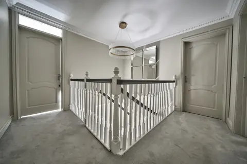 Landing with a white balustrade and Off Black handrail between two pale panelled doors, a ring light and mirror panels