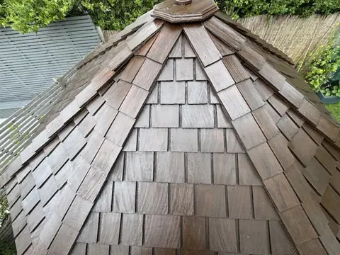 Cedar shingle roof seen from above after staining, an even rich brown on every shingle